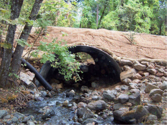 An image of water flowing through the culvert on conner creek at red hill road.