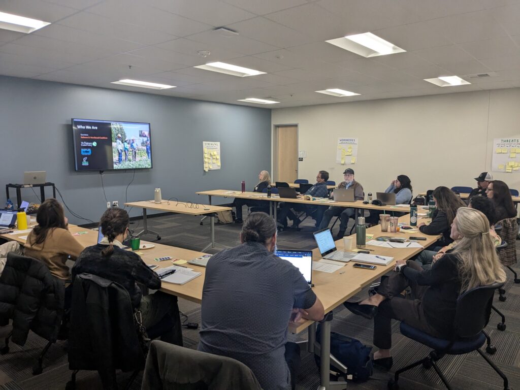 Forum members gathered around listening to a presentation