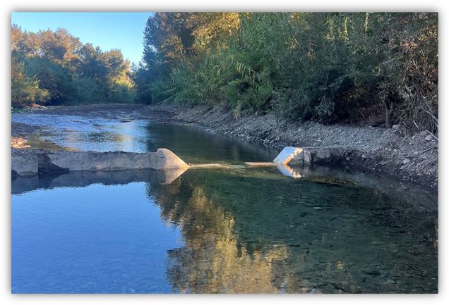 The view of a concrete notch cut into a dam in a river